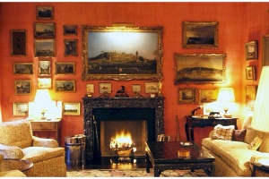 2 of 11 Paul Mellon’s study at the couple’s townhouse in New York City, decorated with the help of several interior designers, including John Fowler, Paul Leonard, Billy Baldwin, and Bruce Budd. Gilt-framed antique landscapes fill the walls, which have been painted a rich coral. 